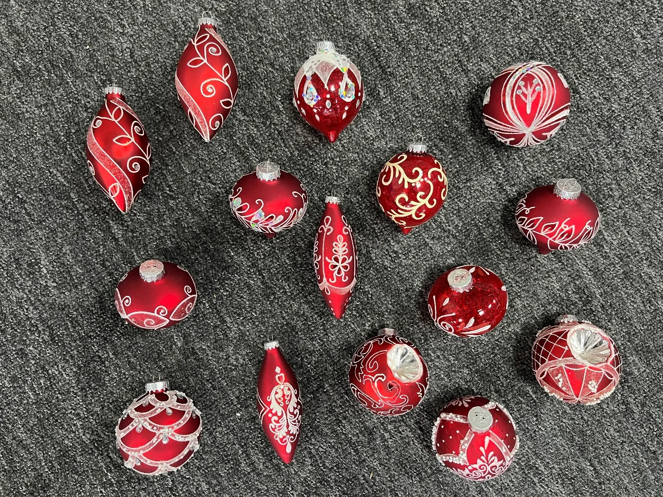 Red glass Christmas hanging ornaments arranged in assorted elongated and round shapes