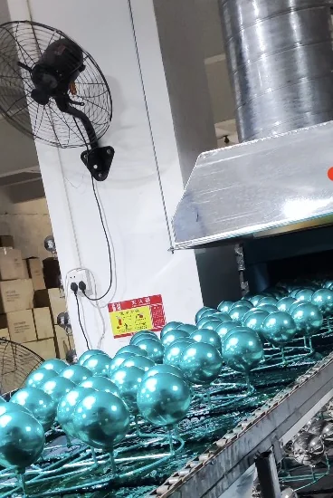 Colored glass ornaments moving through production equipment