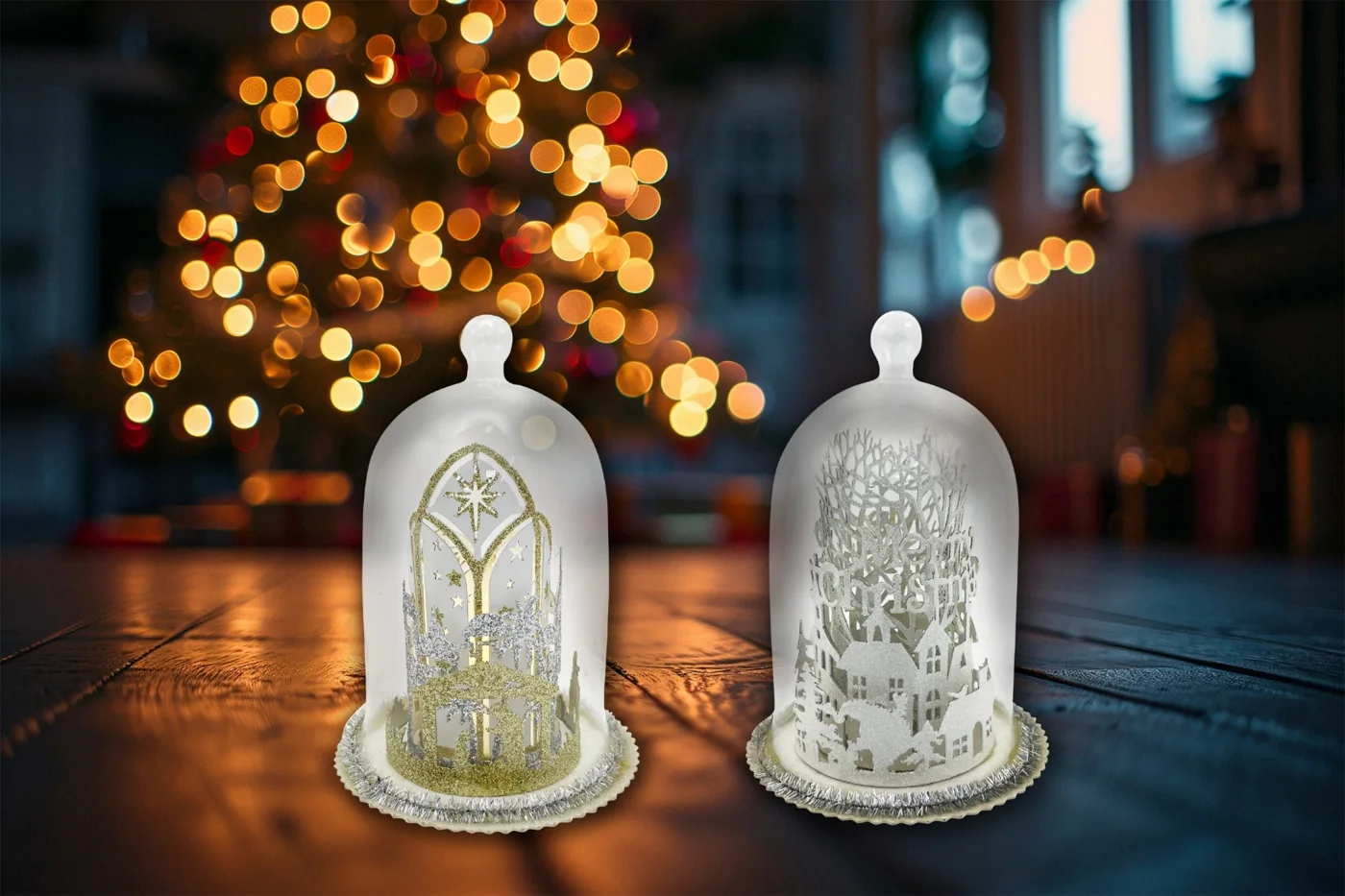 Two illuminated glass cloches with winter village designs
